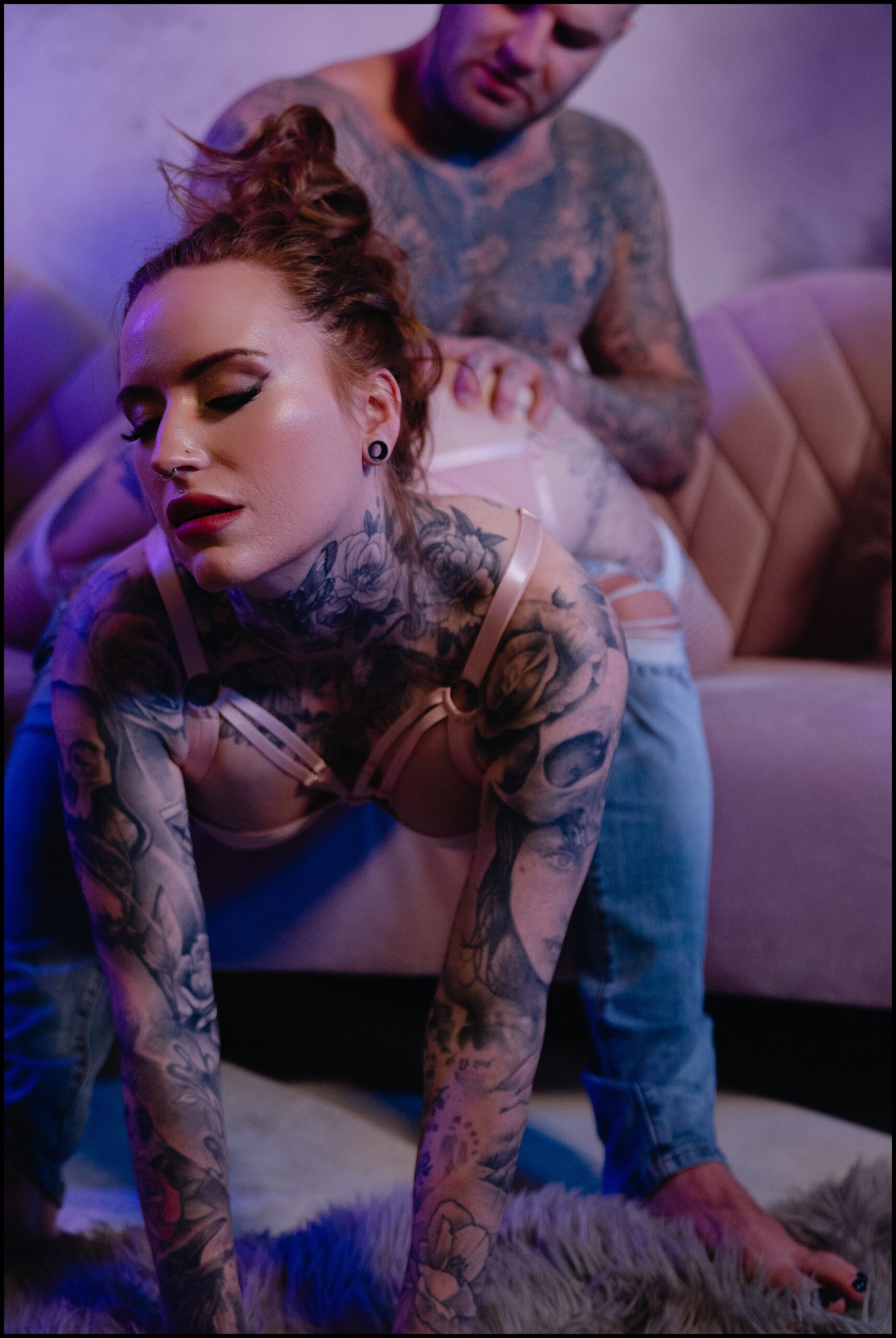 A Tattooed Couple Embraces during their intimate couples boudoir photoshoot. 